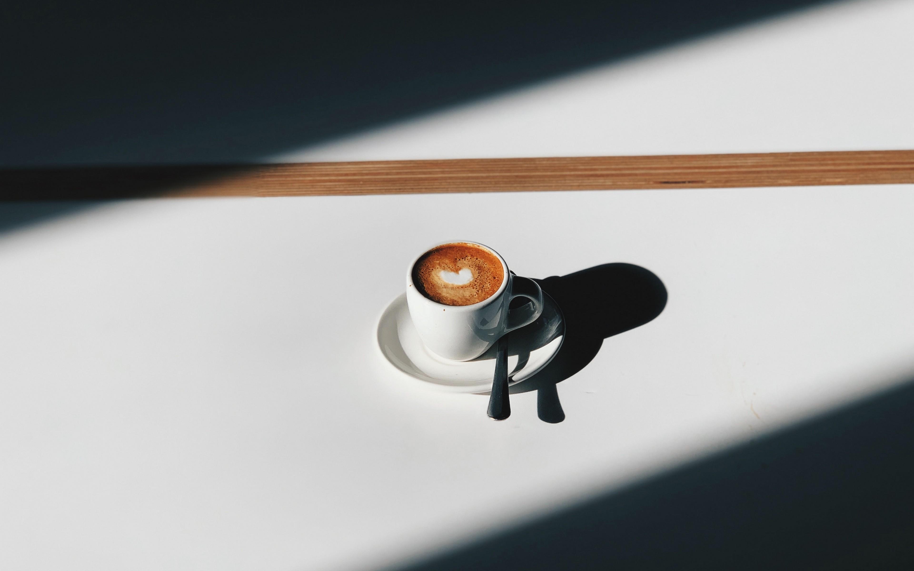 Sunlight across a wooden table with a ceramic mug